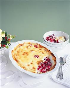 A dish of crème brûlée with orange and cranberries