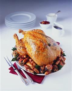 Roast turkey with pistachio stuffing, sausages, bacon-wrapped prunes