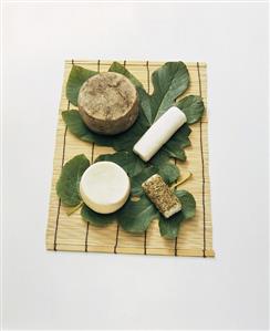 Four different goat's cheeses with fig leaves on table mat