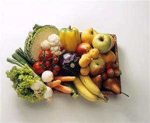 Assorted fruit and vegetables on a wooden tray