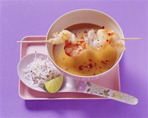 Cold coconut curry soup with skewered prawns