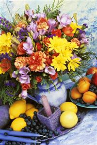 Spring arrangement with chyrsanthemums, freesias, fruit beside it