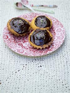 Three lemon buns with chocolate icing on a plate