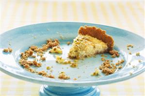 The last piece of passion fruit tart on a cake stand