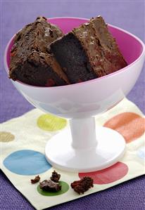 Brownie with pieces of red pepper in a small pedestal bowl