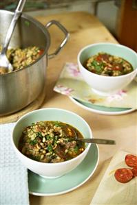 Barley soup with spinach, sausage and ham