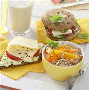 Scrambled egg on bread, orange muesli, filled roll, milk