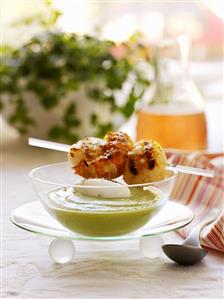 Pea cream soup with skewered prawns