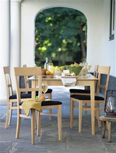 Cheese, fruit and white wine on table on terrace