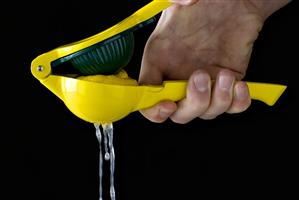 Squeezing a lemon with a citrus squeezer