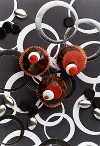 Three cupcakes with chocolate icing & coloured chocolate beans