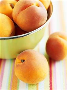 Fresh apricots in and beside a bowl