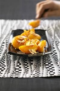 Fried peaches with caramel and flaked almonds