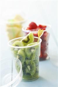 Assorted fruits with cocktail sticks in plastic tubss