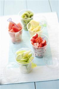 Assorted fruits with cocktail sticks in plastic tubs