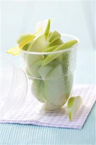 Slices of Granny Smith apples, cocktail stick in plastic tub