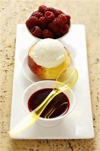 Peach with vanilla ice cream and raspberry sauce