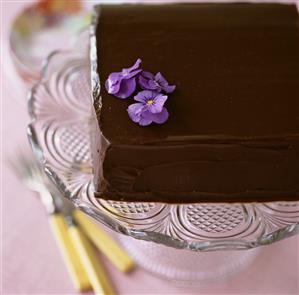 Square chocolate cake decorated with purple flowers