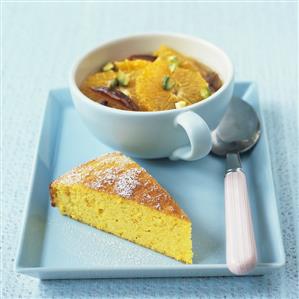 A piece of orange cake and orange salad with pistachios