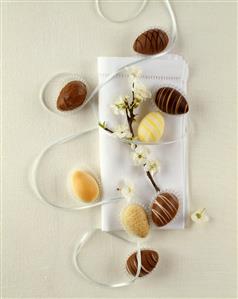 Chocolate Easter eggs and white napkin with flowering twig