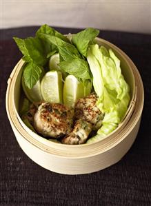 Chicken burgers with lime wedges & lettuce in steaming basket