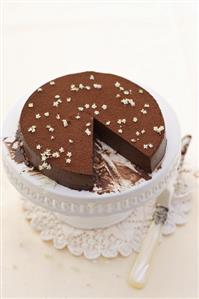 Chocolate truffle cake with elderflowers, a piece removed