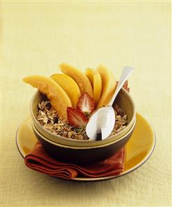 Muesli with melon and peach slices and strawberries