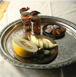 Honeydew melon, tea and dried fruit on a tray