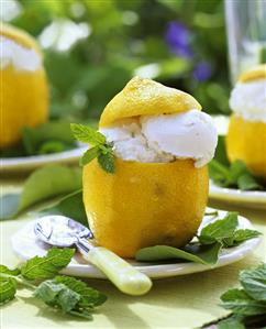 Lemon ice cream in hollowed-out lemon with lemon balm