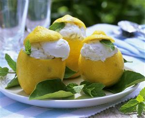 Lemon ice cream in hollowed-out lemon with lemon balm