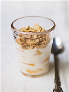 Yoghurt with peach and wholemeal cornflakes in a glass.  Receta disponible TR