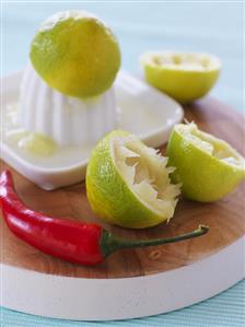 Squeezed limes, citrus squeezer and red chilli