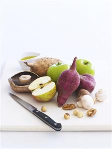 Fruit, mushrooms, vegetables and nuts with knife