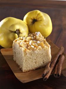 A piece of almond cake with quinces and cinnamon sticks