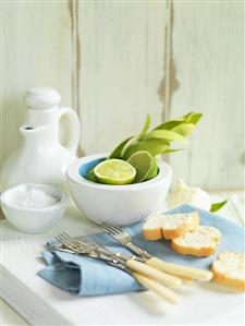 Still life with forks, slices of bread, limes and salt