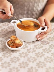 Woman eating sweet potato soup