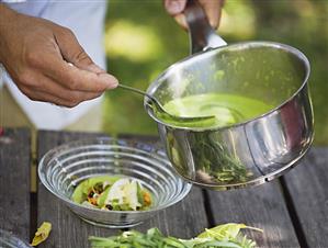 Serving green pea soup with mussels