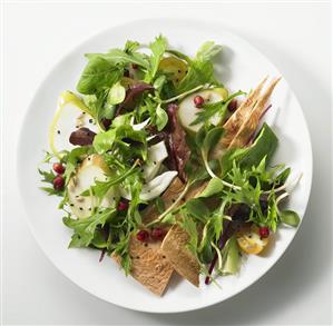 Green salad with pear slices and pomegranate seeds