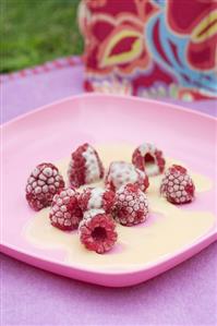 Frozen raspberries with white chocolate sauce