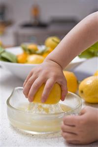 Child's hand squeezing a lemon