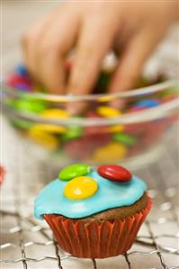 Decorating a chocolate cupcake with chocolate beans