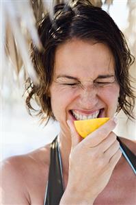 Woman biting into a lemon (and pulling a face)