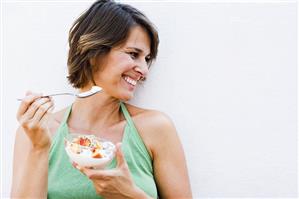 Woman eating muesli with fruit