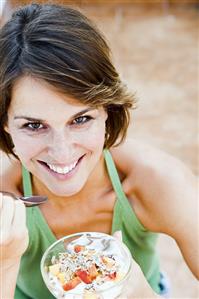 Woman eating muesli with fruit