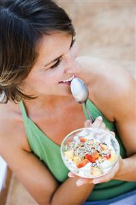 Woman eating muesli with fruit