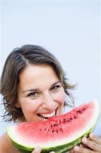 Young woman eating a slice of watermelon