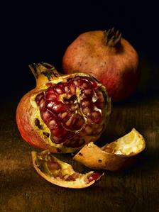 Two pomegranates, one partly peeled