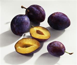 Whole and halved plums (variety: Auerbach)