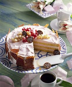 Orange birthday cake with red- & white currants & brittle