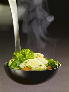 Ladle full of vegetable stew and semolina dumpling